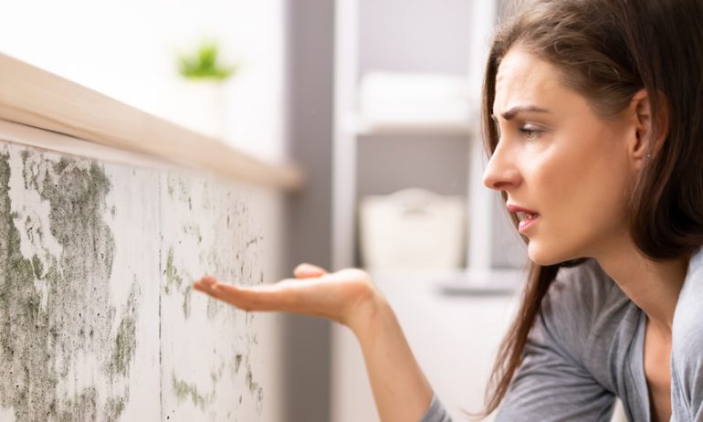 Femme regardant la moisissure dans son appartement
